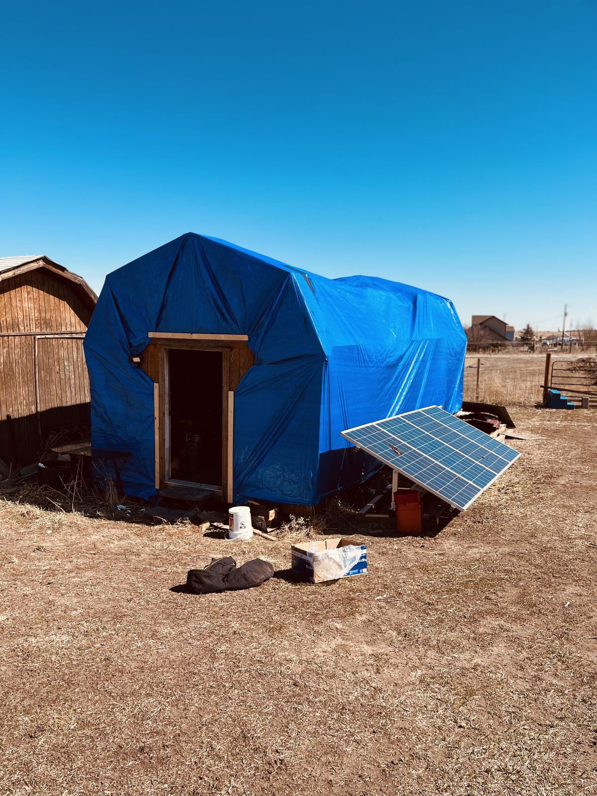 Completed emergency tarp protecting fire-damaged structure